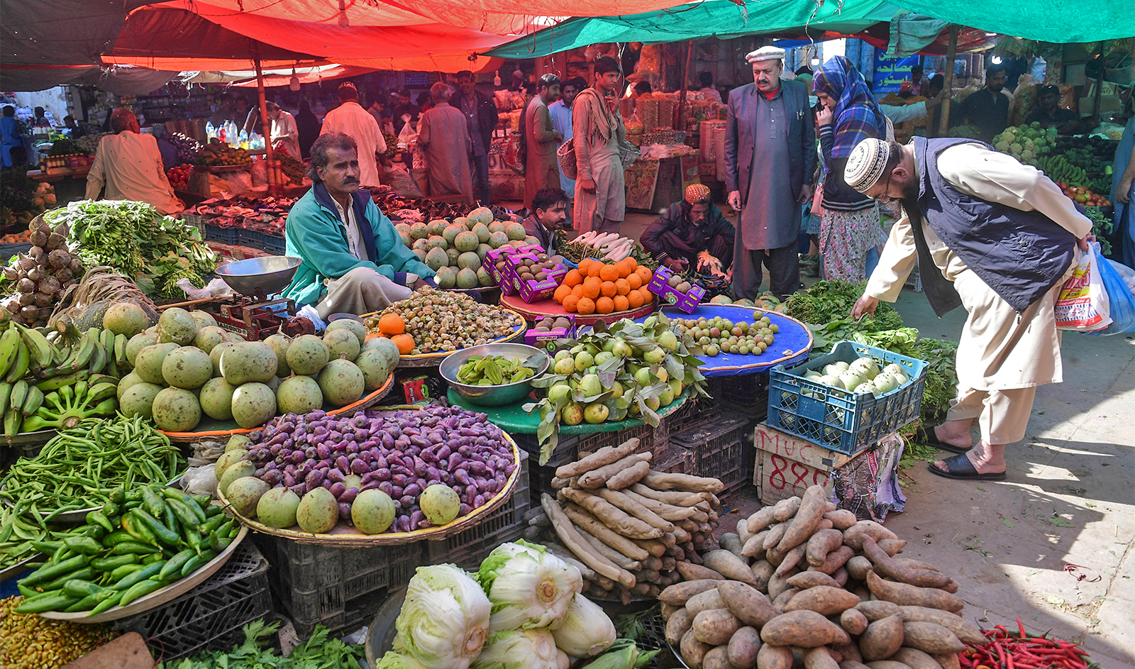 This picture taken on January 30, 2023 shows residents buying vegetable at a market in Pakistan's port city of Karachi. (AFP)