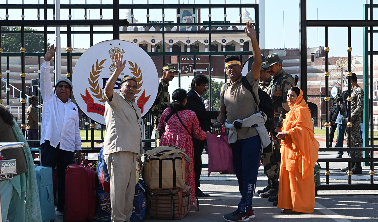 Indian Hindu pilgrims wave before crossing over to Pakistan to participate in the 314th birth anniversary celebrations of Shiv Avtari Satguru Sant Shadaram Sahib at the historic Shadani Darbar in Hayat Pitafi, at India-Pakistan Wagah border post about 35km from Amritsar on November 22, 2022. (AFP/FILE)