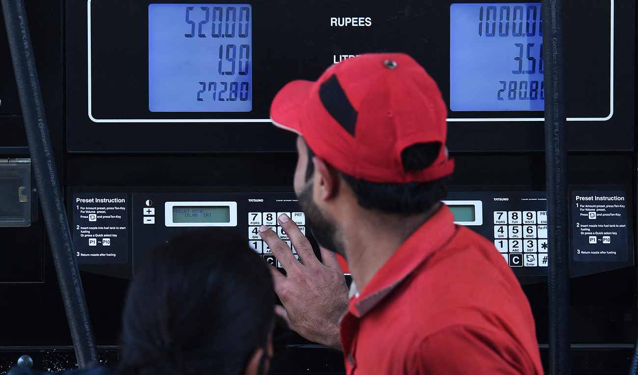 An employee of a petrol station fills the tank of a customer in Karachi on February 16, 2023, after a hike in prices of petroleum products by the government. (Photo courtesy: AFP)