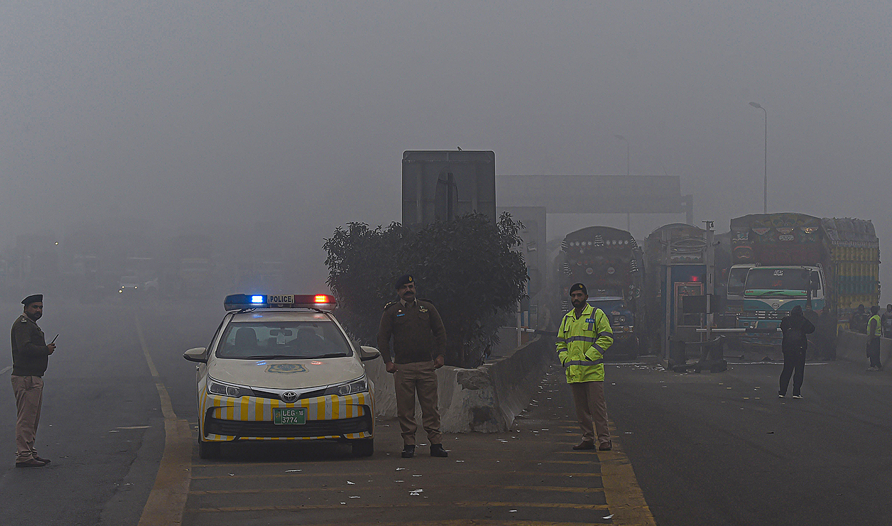 In this file photo taken on December 16, 2021, traffic policemen stand along a motorway in Lahore. (Photo courtesy: AFP/File)