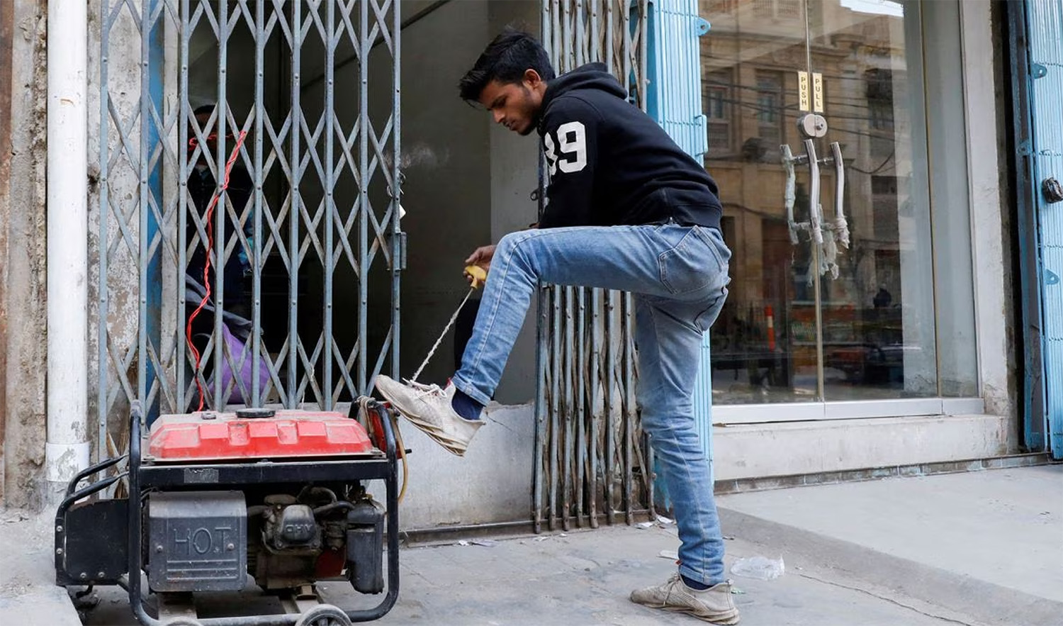 A man starts a generator outside his shop during a country-wide power breakdown in Karachi, Pakistan on January 23, 2023. (REUTERS/File)