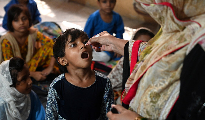 A health worker administers polio vaccine drops to a child at a school during a door-to-door polio vaccination campaign in Lahore on August 22, 2022. (AFP/File)
