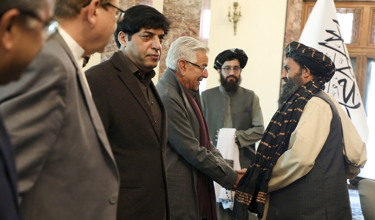 Mullah Abdul Ghani Baradar, the Taliban-appointed deputy prime minister for economic affairs, right, shakes hands with Pakistan's defense minister, Khawaja Mohammad Asif, during a meeting in Kabul, Afghanistan, on February 22, 2023. (Deputy Prime Minister Minister Office via AP)