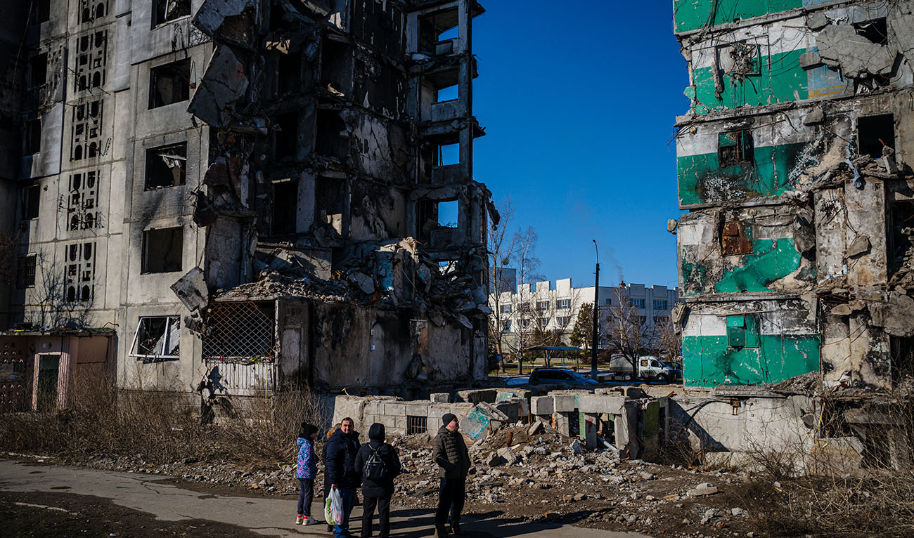 Ukrainian bystanders look on to residential buildings that were destroyed during an attack, in Borodyanka on February 23, 2023. (Photo courtesy: AFP/FILE)