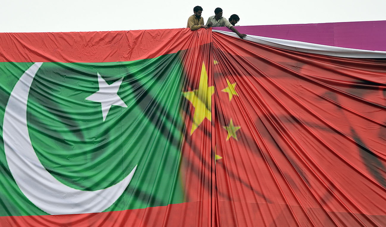 Pakistani labourers arrange a welcome billboard featuring the Chinese and Pakistani national flags ahead of the forthcoming visit by Chinese President Xi Jinping in Islamabad on April 18, 2015. (AFP/FILE)