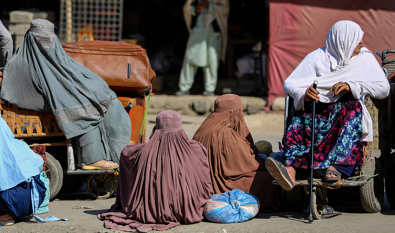 This photo, taken on February 23, 2023, shows Afghan women wearing burqas waiting to cross into Pakistan at the Torkham border crossing in Khyber district, Pakistan. (Photo courtesy: AFP)