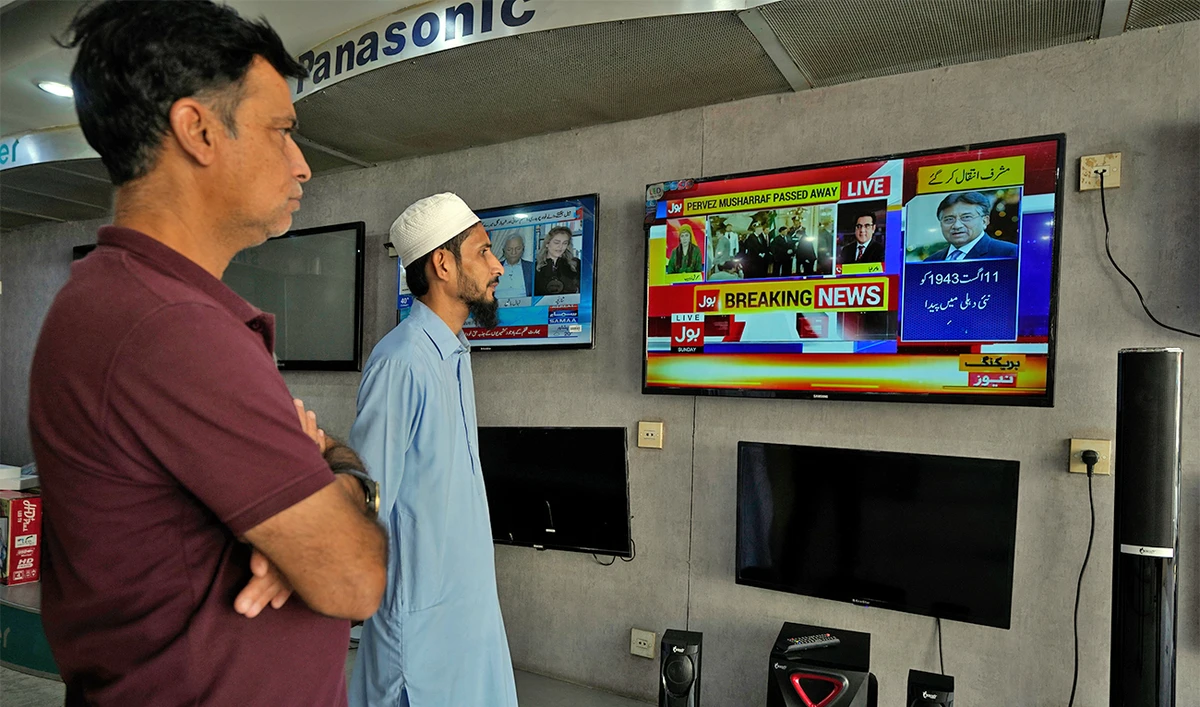 People watch a TV news report about the death of former Pakistani President Gen. Pervez Musharraf at a TV shop in Karachi, Pakistan, on February 5, 2023.(AP)