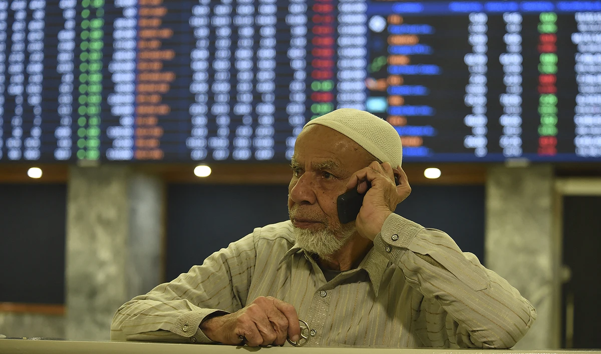 A broker talks on a phone as he watches latest share prices at the Pakistan Stock Exchange in Karachi on January 27, 2023. (Photo courtesy: AFP/File)