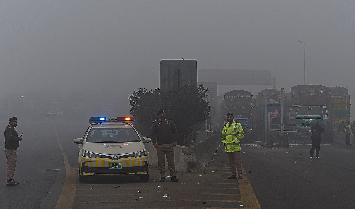 In this file photo taken on December 16, 2021, traffic policemen stand along a motorway in Lahore. (Photo courtesy: AFP/File)