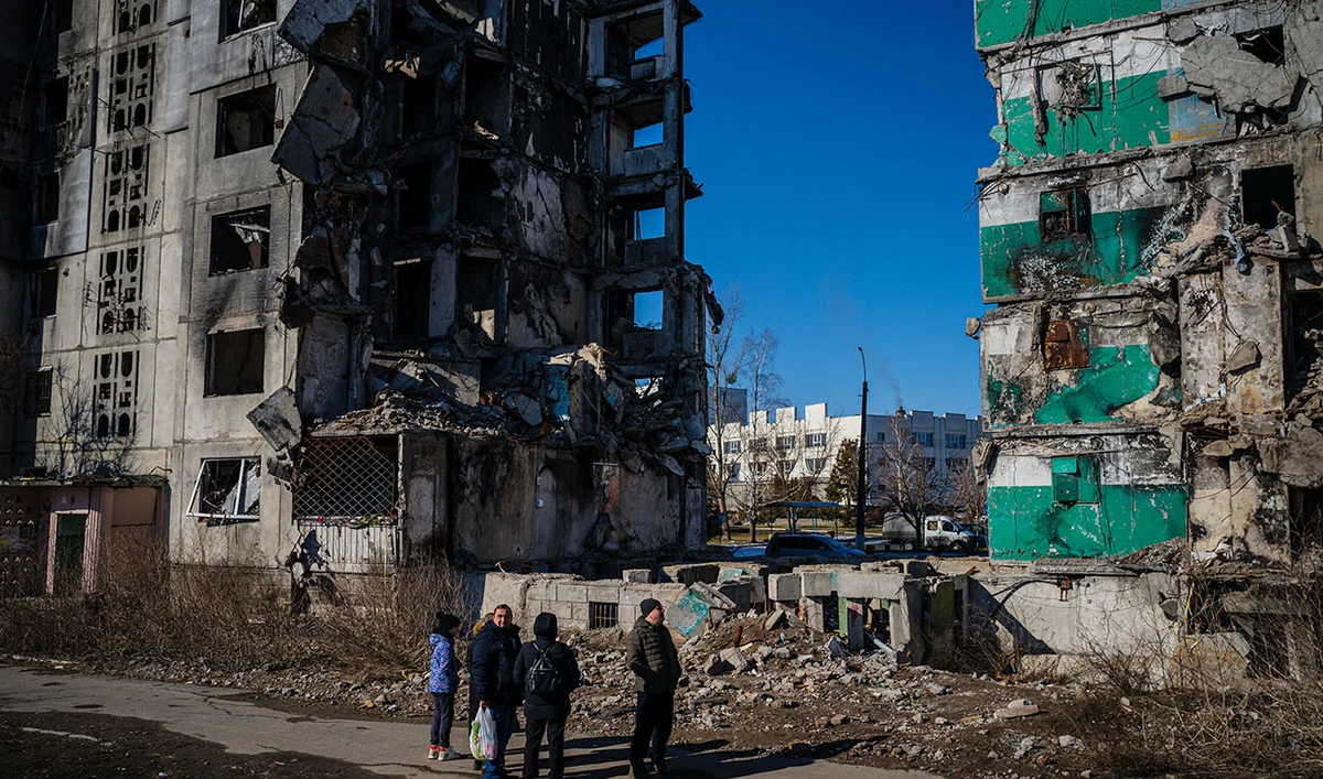Ukrainian bystanders look on to residential buildings that were destroyed during an attack, in Borodyanka on February 23, 2023. (Photo courtesy: AFP/FILE)