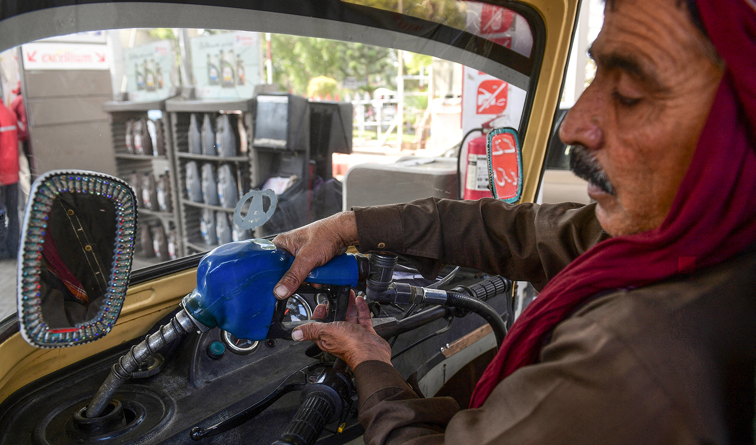 This picture taken on January 30, 2023 shows a man filling petrol in his auto-rickshaw at a gasoline station in Pakistan's port city of Karachi. (AFP/File)