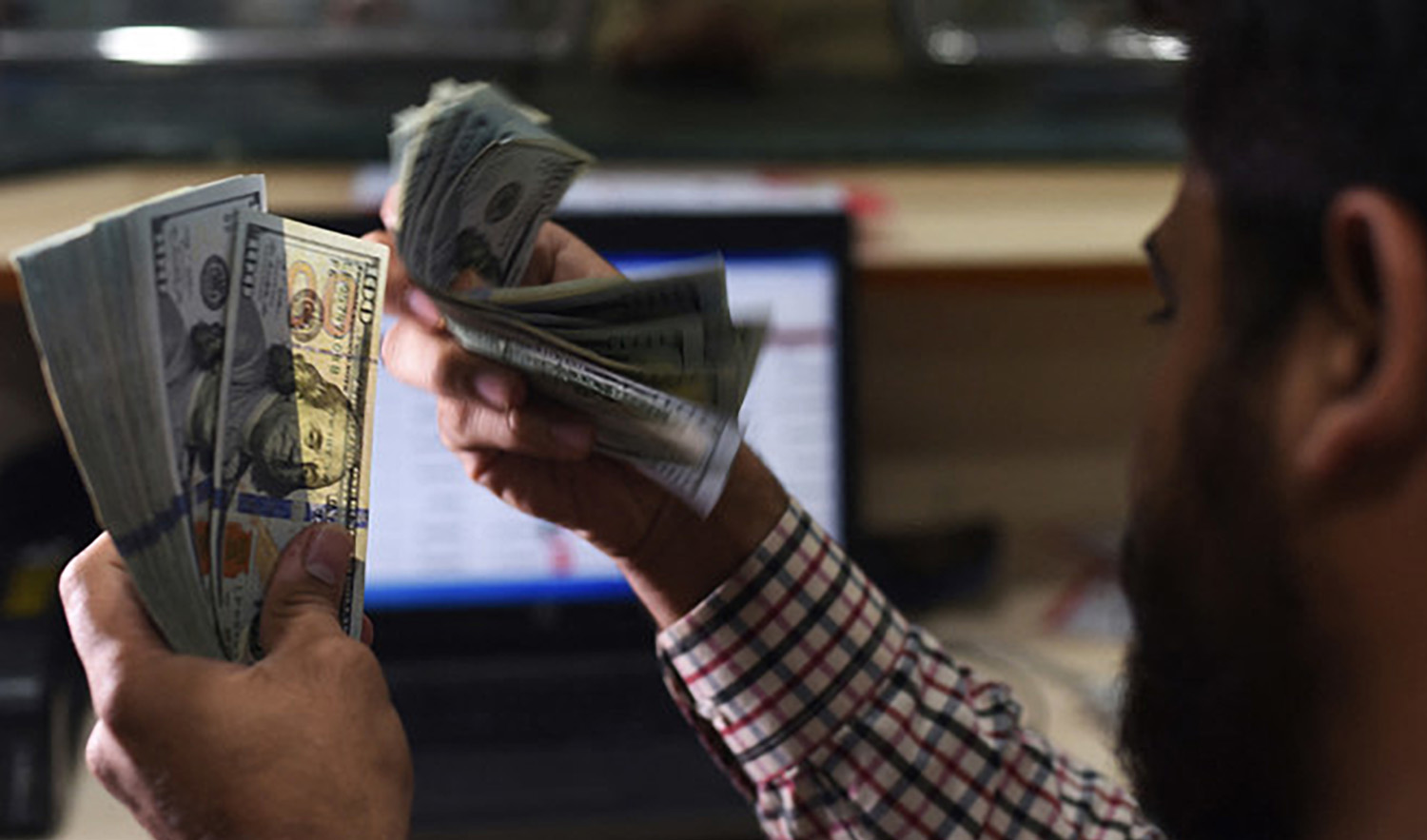 A Pakistani dealer counts US dollars at a currency exchange shop in Karachi, Pakistan, on October 9, 2018. (AFP/File)