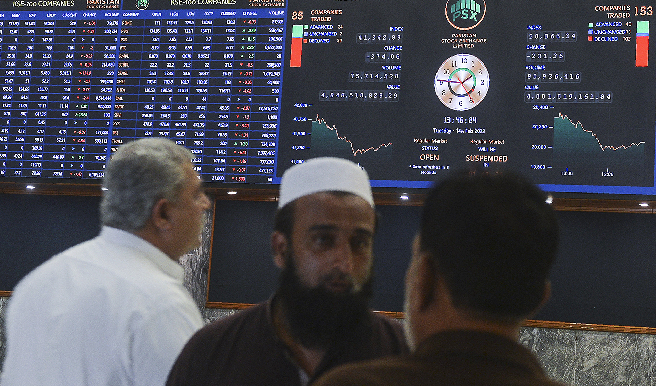 In this photo, taken on February 14, 2023, brokers look at an index board showing the share prices at the Pakistan Stock Exchange in Karachi. (Photo courtesy: AFP/File)
