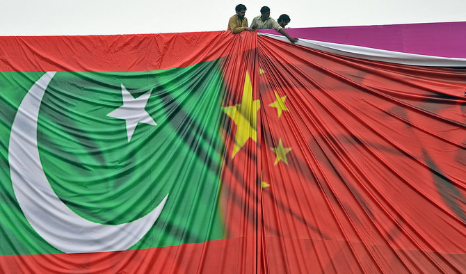 In this file photo, taken on April 18, 2015, Pakistani labourers arrange a billboard featuring the Chinese and Pakistani national flags in Islamabad, Pakistan. (Photo courtesy: AFP/File)