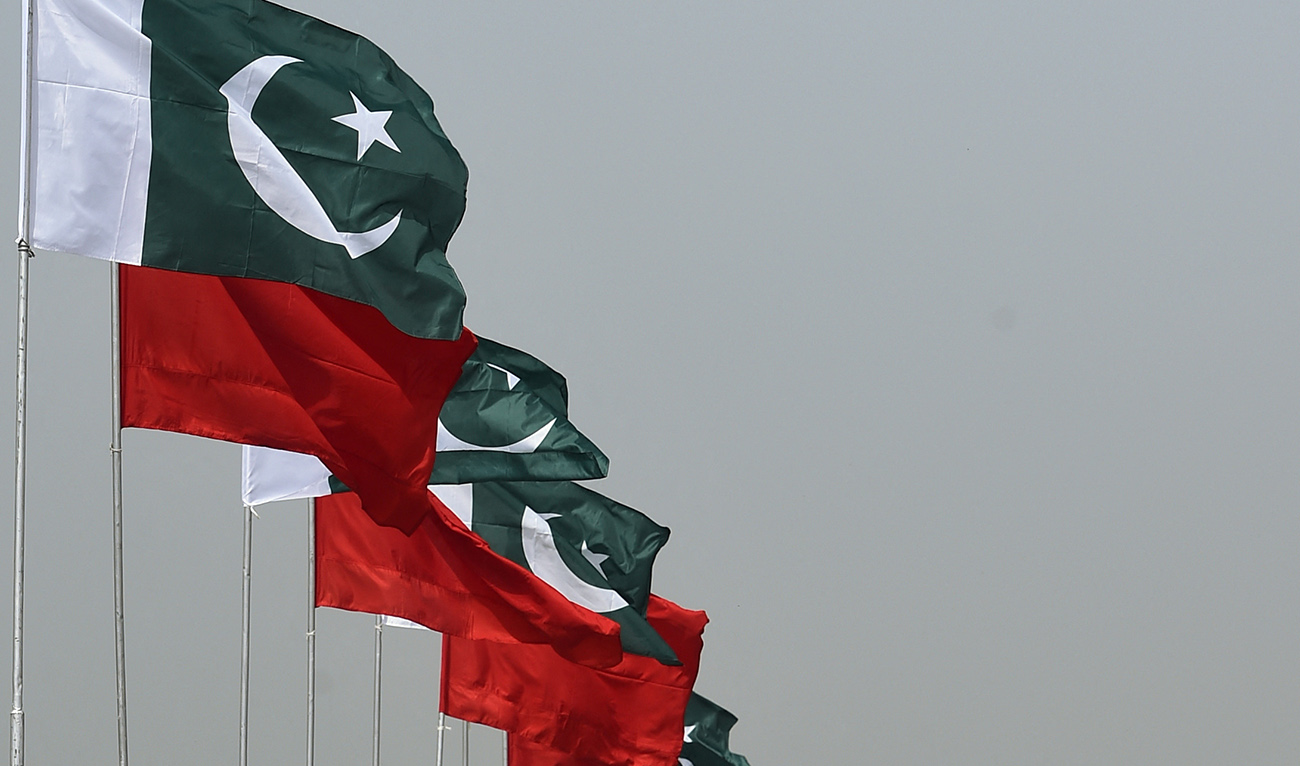 Pakisan residents walk past the Pakistan and Chinese national flags hung ahead of the forthcoming visit by Chinese President Xi Jinping in Islamabad on April 18, 2015. (AFP/FILE)