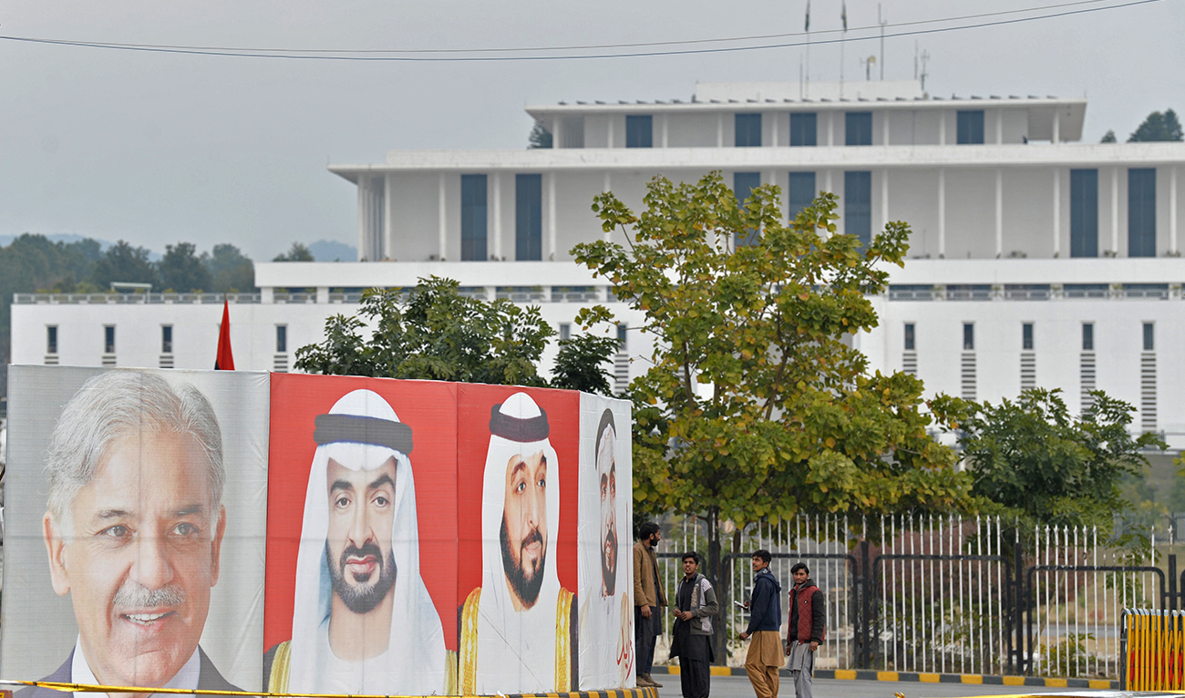 Workers arrange portraits of UAE President Sheikh Mohamed bin Zayed al-Nahyan (C) and Pakistan Prime Minister Nawaz Sharif (L) along the constitution avenue in Islamabad on January 29, 2023. (AFP/FILE)