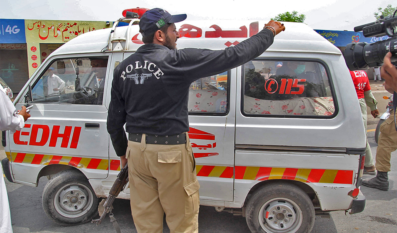 A Pakistani policeman stands alongside an ambulance in Multan, Pakistan, on July 16, 2016. (AFP/File)