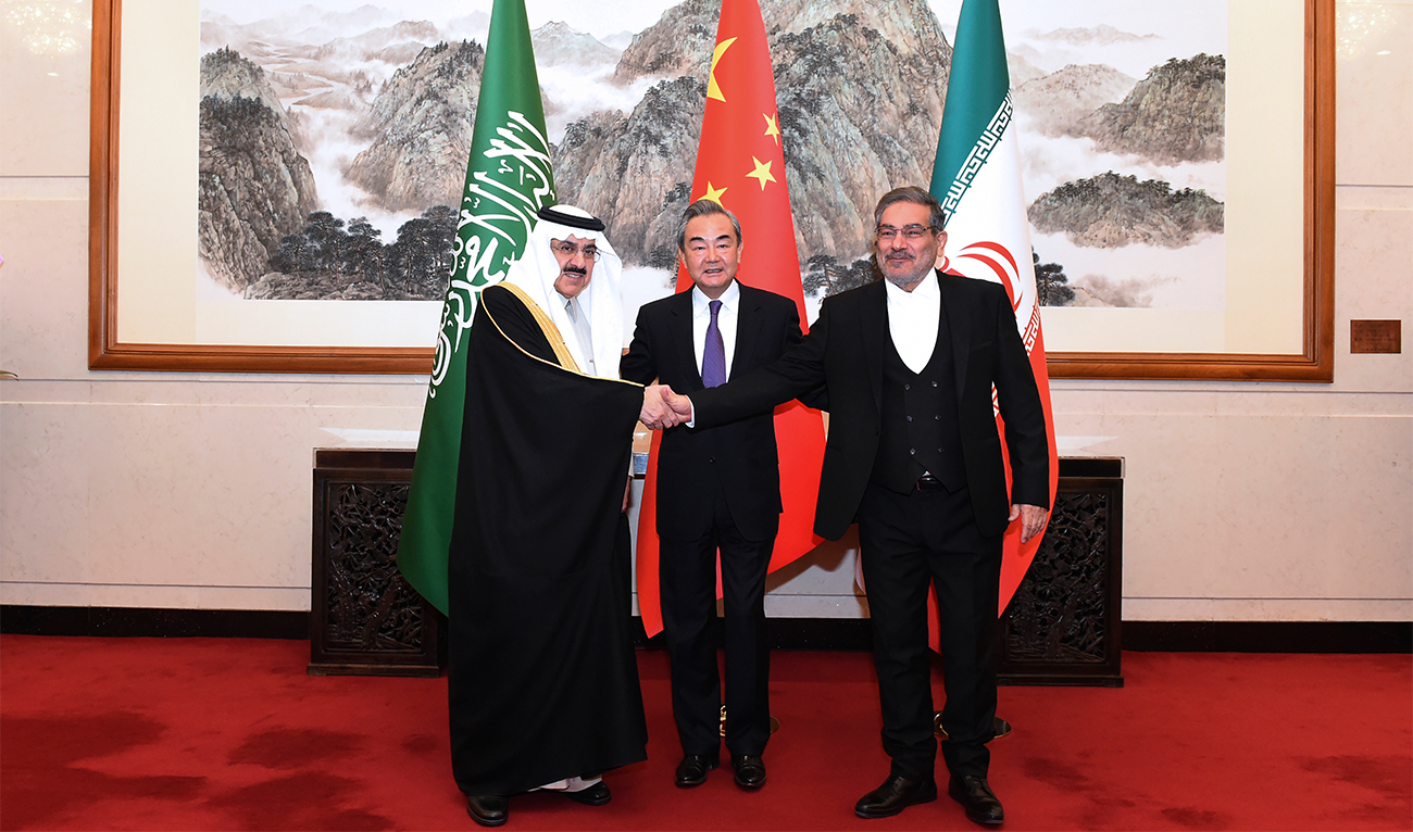 In this photo released by Xinhua News Agency, Ali Shamkhani, the secretary of Iran's Supreme National Security Council, at right, shakes hands with Saudi national security adviser Musaad bin Mohammed al-Aiban, at left, as Wang Yi, China's most senior diplomat, looks on, at center, for a photo during a closed meeting held in Beijing, on March 11, 2023. (Xinhua via AP)