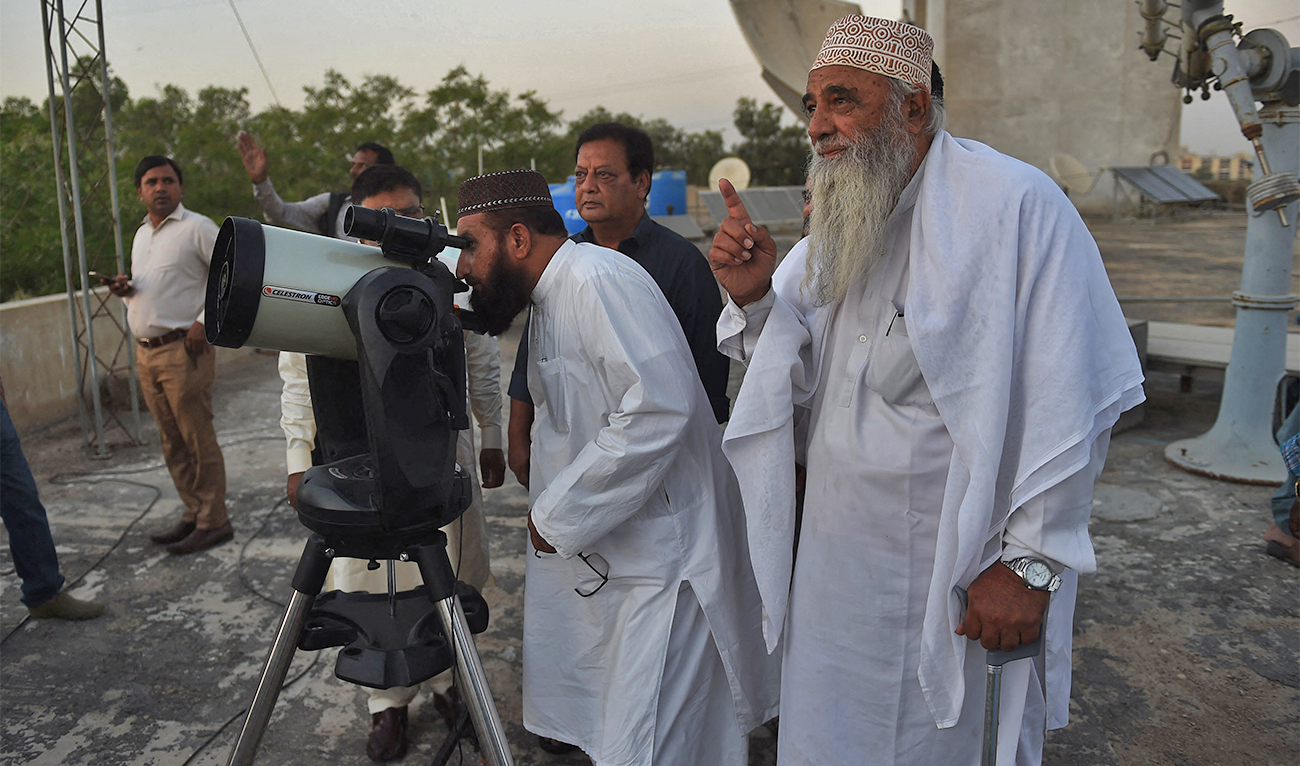 Members of Ruet-e-Hilal zonal committee observatory use a telescope to watch the first crescent of the Ramadan moon in Karachi, Pakistan, on April 2, 2022. (AFP/File)