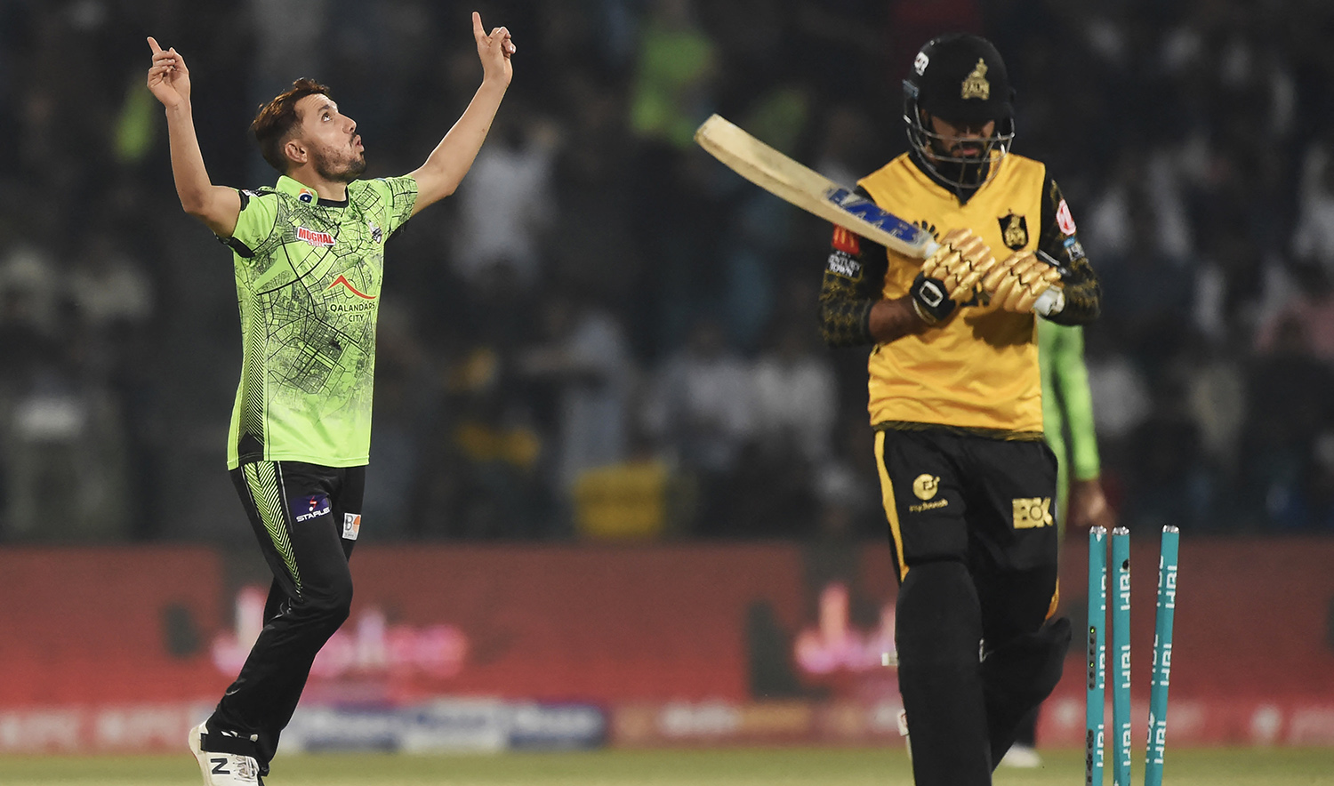 Lahore Qalandars Zaman Khan, left, celebrates the dismissal of Peshawar Zalmi's Aamer Jamal during the Pakistan Super League (PSL) Twenty20 cricket eliminator match at the Gaddafi Cricket Stadium in Lahore on March 17, 2023. (AFP)
