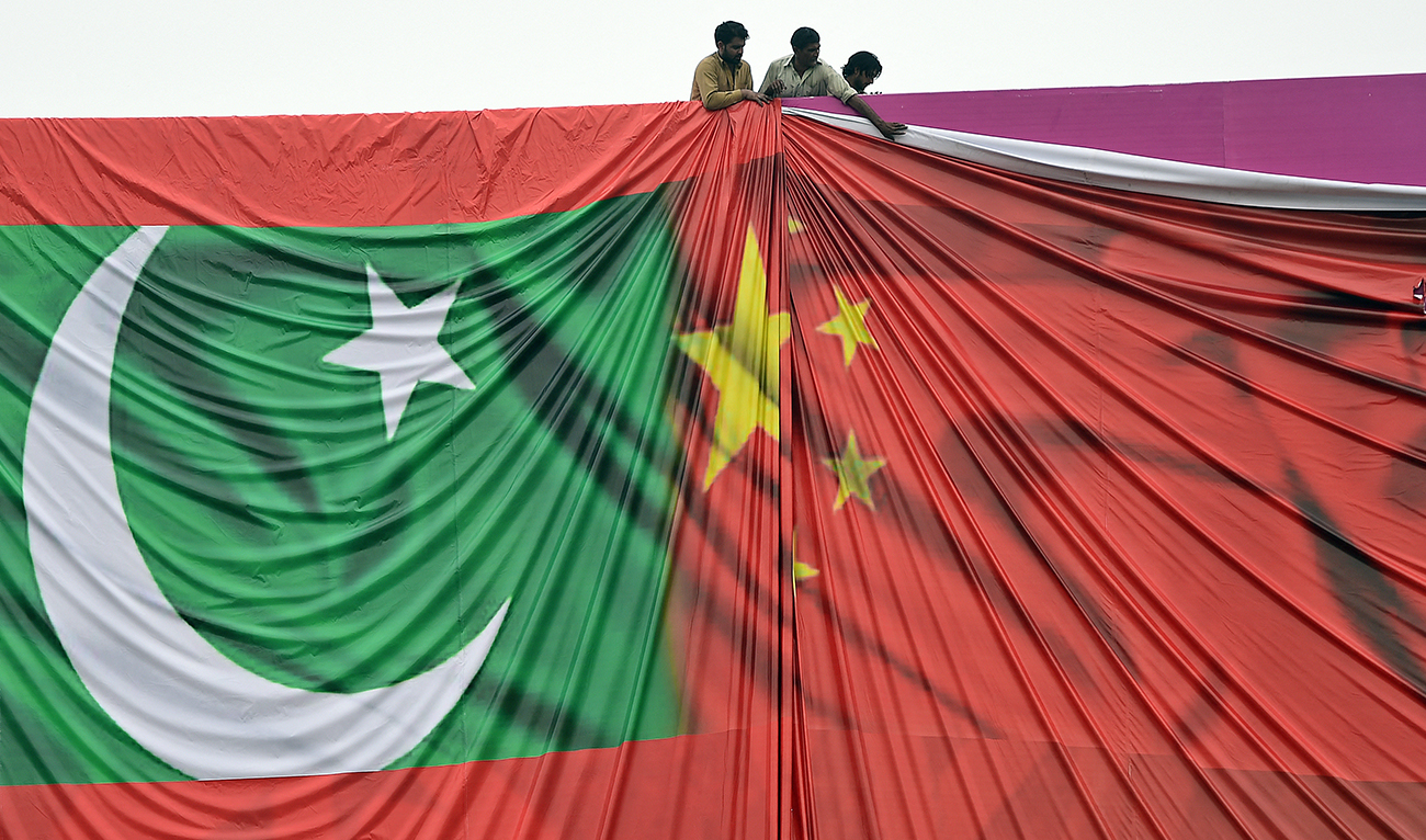 Pakistani labourers arrange a welcome billboard featuring the Chinese and Pakistani national flags ahead of the forthcoming visit by Chinese President Xi Jinping in Islamabad on April 18, 2015. (AFP/FILE)
