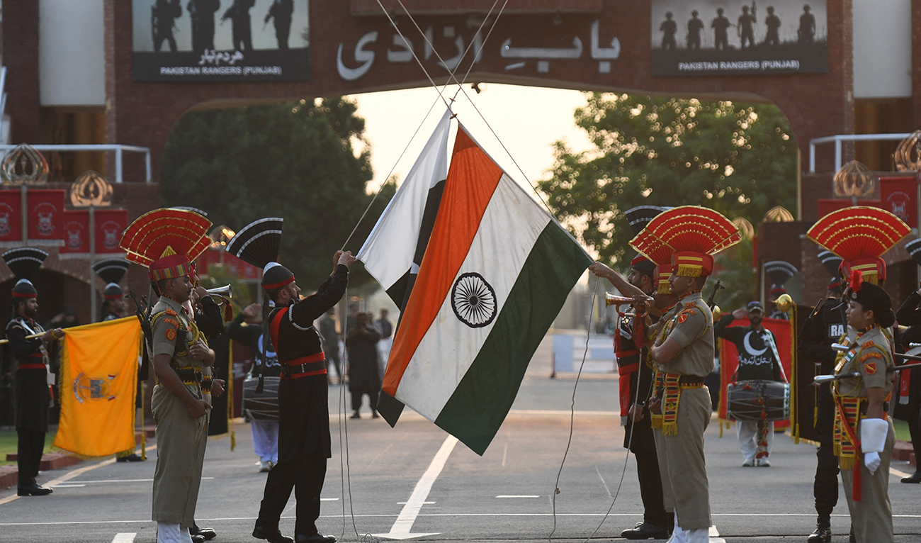 Indian Border Security Force (BSF) personnel and Pakistani Rangers (in black) lower their respective flag during the daily beating retreat at the India-Pakistan Wagah Post some 35 Km from Amritsar on September 17, 2021. (AFP/FILE)