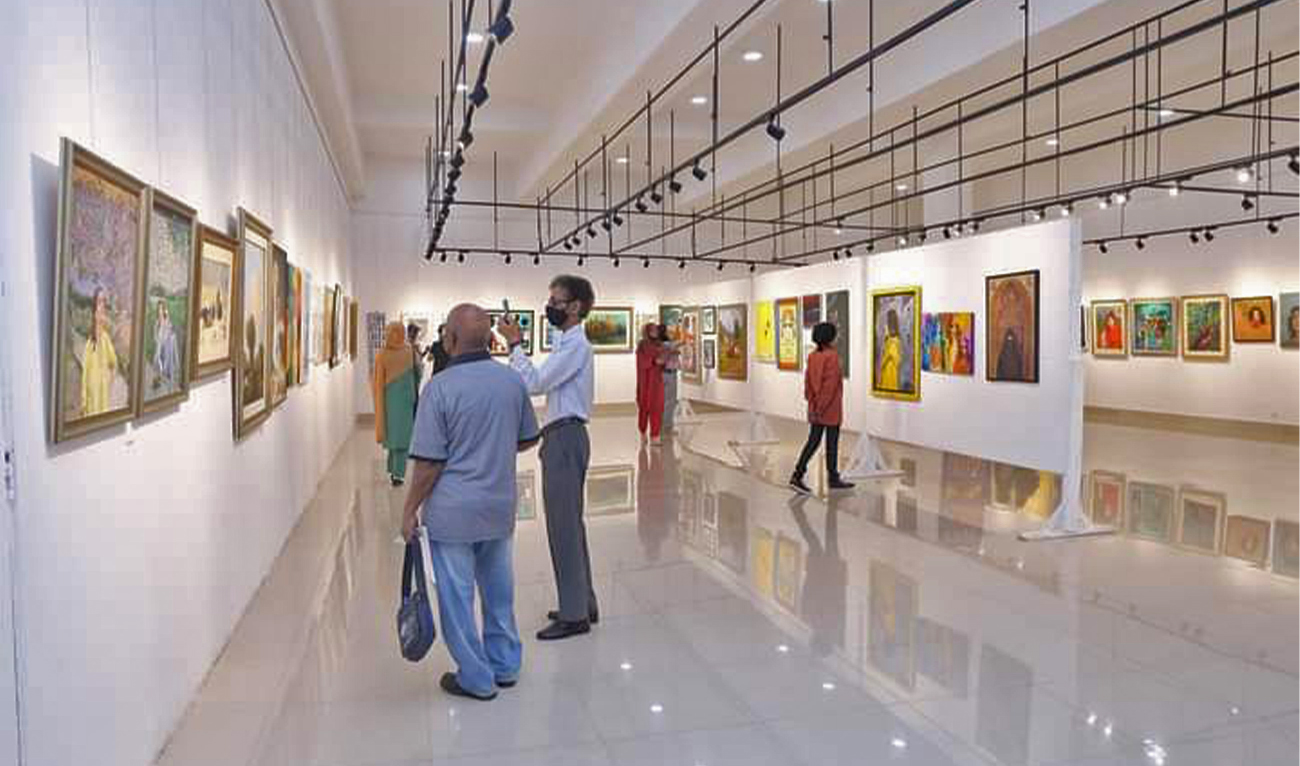 Visitors witness paintings on display during the three-day National Art Exhibition 2023 at the Ahmed Parvez Art Gallery at Arts Council of Pakistan Karachi, on March 17, 2023. (Photo courtesy: ACP)