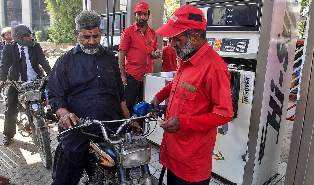 This picture taken on January 30, 2023 shows resident Saleem Qureshi (C) filling petrol in his motorcycle at a gasoline station in Pakistan's port city of Karachi. (AFP/File)