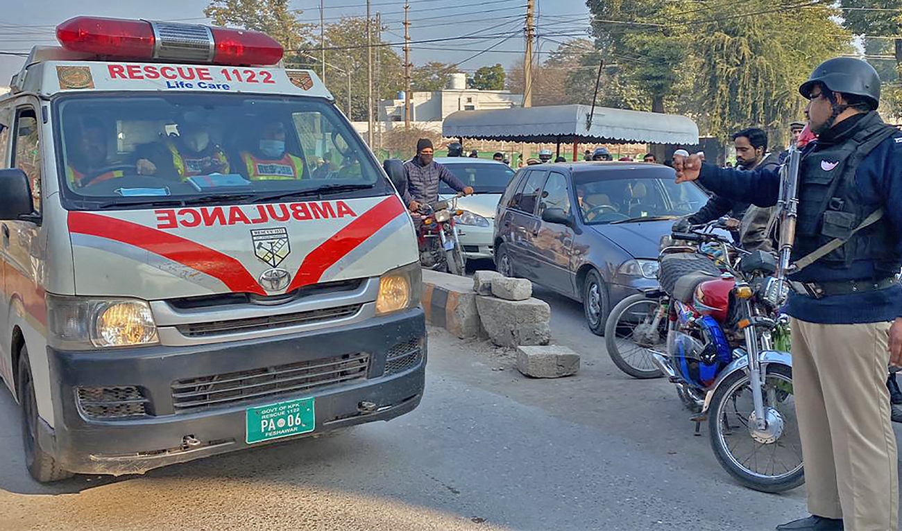 A policeman makes way for an ambulance in Peshawar on January 31, 2023. (AFP/File)