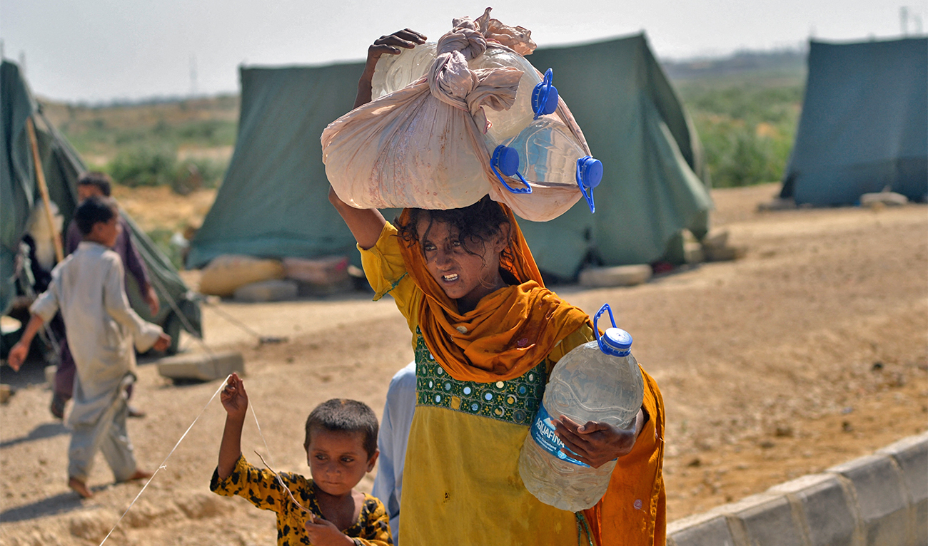 Internally displaced flood-affected people arrive to collect drinking water at Kotri in Jamshoro district of Sindh province on September 28, 2022. (AFP/File)