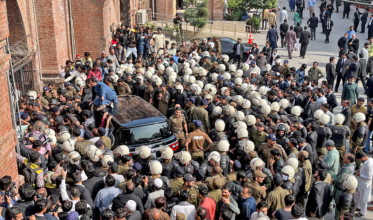 Police officers escort the vehicle of former Pakistani Prime Minister Imran Khan, as he appears at the district High Court in Lahore, Pakistan on March 21, 2023. (REUTERS)