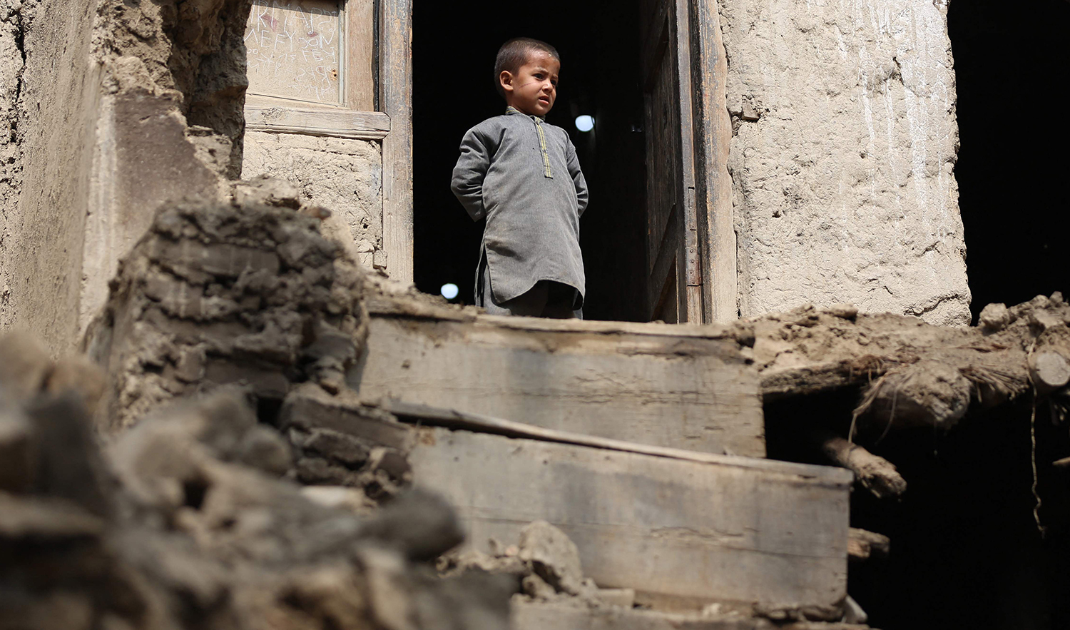 A boy looks out from his damaged home in Miya village, in Alishing District of Laghman Province on March 22, 2023, following an overnight earthquake. (AFP)