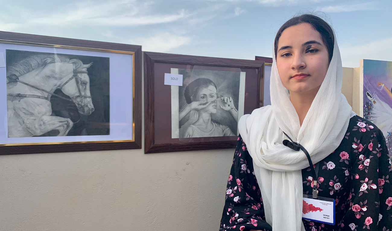 Afghan refugee girl student, Raqqa Nadri briefs about her art work displayed in an exhibition in Islamabad, Pakistan on March 22, 2023. (AN Photo)