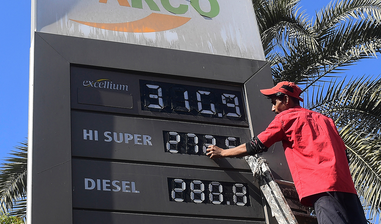 In this photo, taken on February 16, 2023, an employee of a petrol station updates the latest fuel prices on a board in Karachi. (Photo courtesy: AFP)