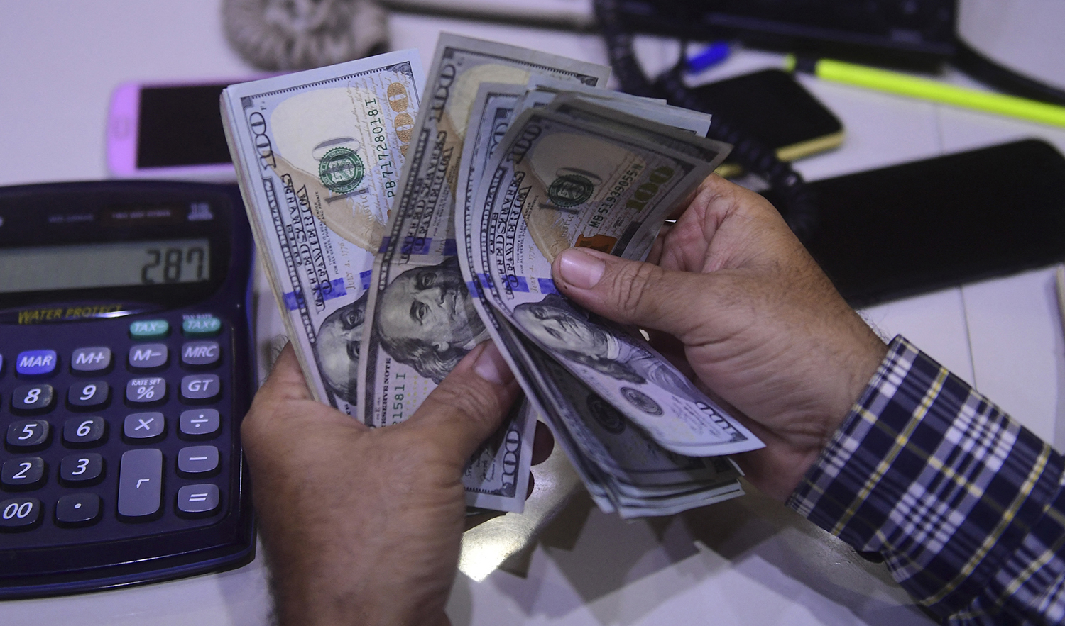 A dealer counts US dollars at a money exchange market in Karachi, Pakistan on March 2, 2023. (AFP)