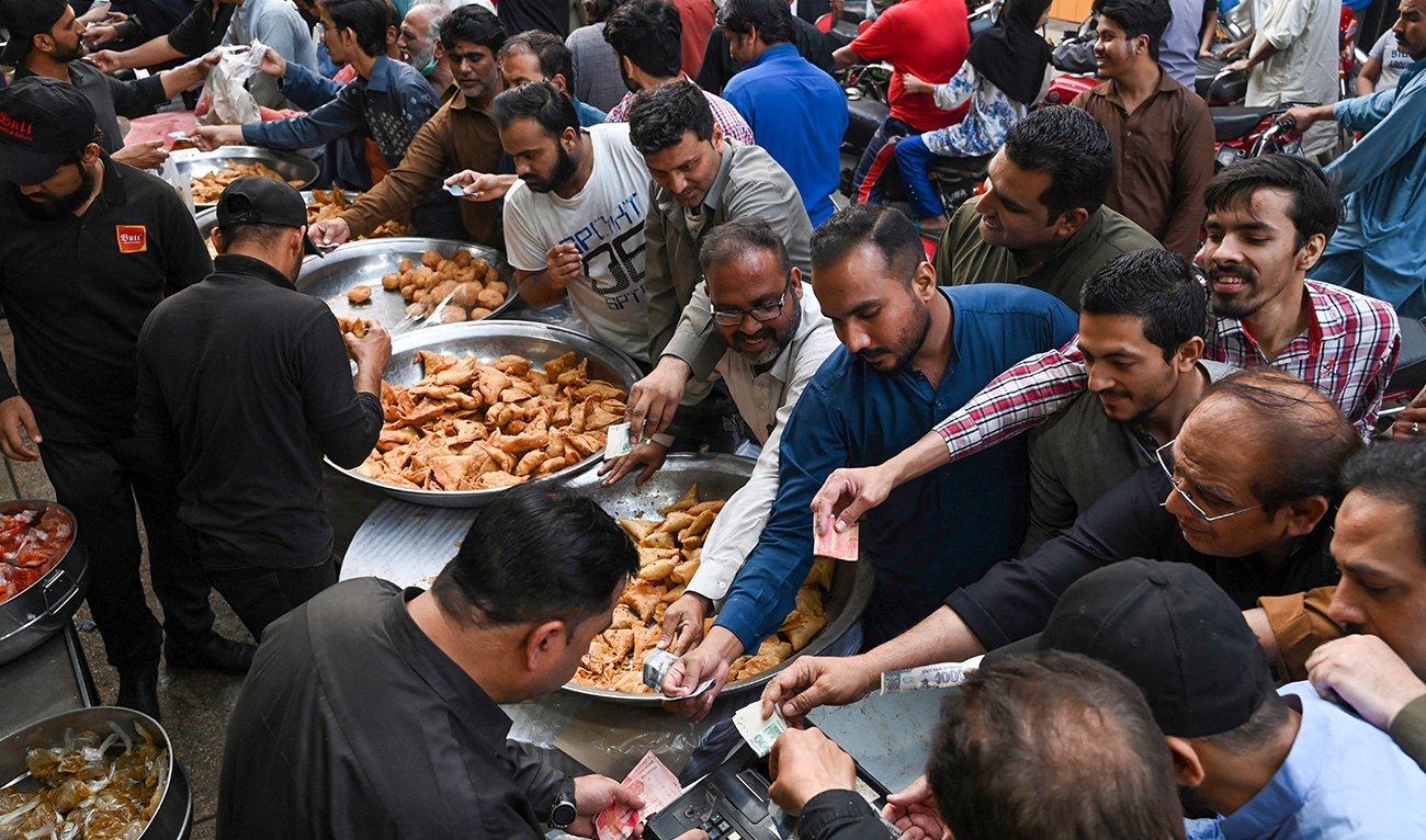 Muslim devotees buy Iftar food at a market before breaking their fast on the first day of the holy month of Ramadan, in Lahore on March 23, 2023. (AFP/FILE)