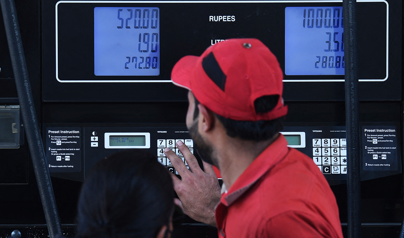 An employee of a petrol station fills the tank of a customer in Karachi on February 16, 2023, after a hike in prices of petroleum products by the government. (AFP/File)