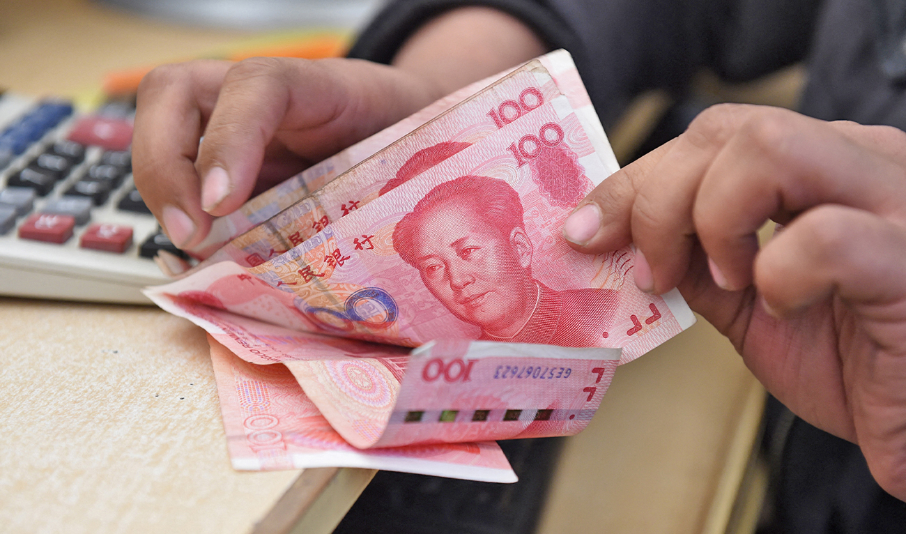 A Pakistani currency dealer counts Chinese currency for his customer at his shop in Quetta, Pakistan, on January 3, 2018. (AFP/File)