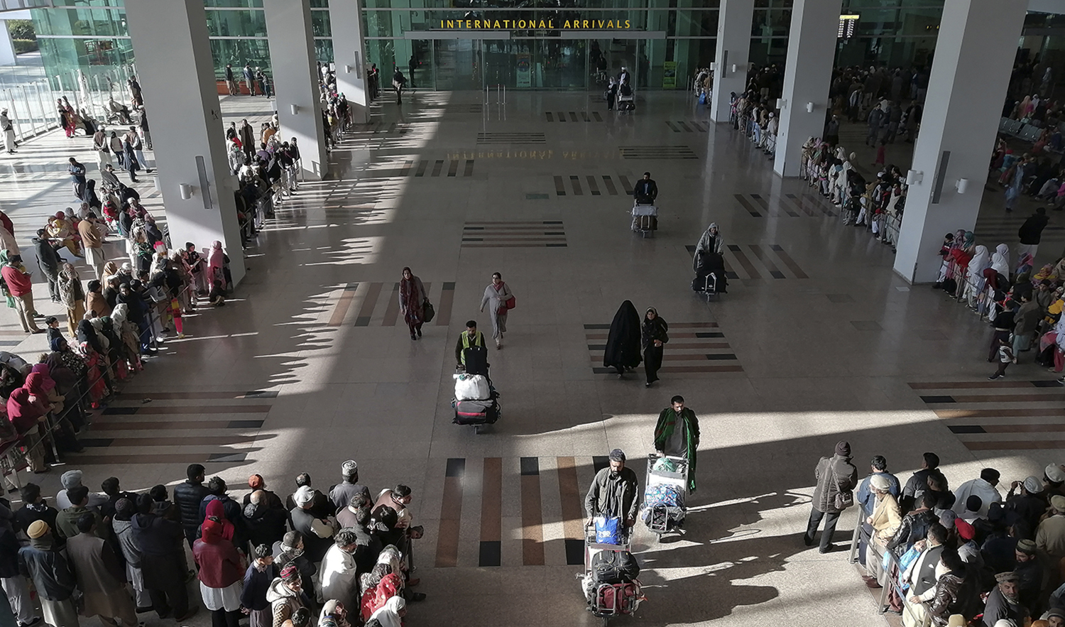 People gather to receive arriving passengers at the international arrival area of the Islamabad International Airport in Islamabad, Pakistan on February 3, 2020. (AFP/File)