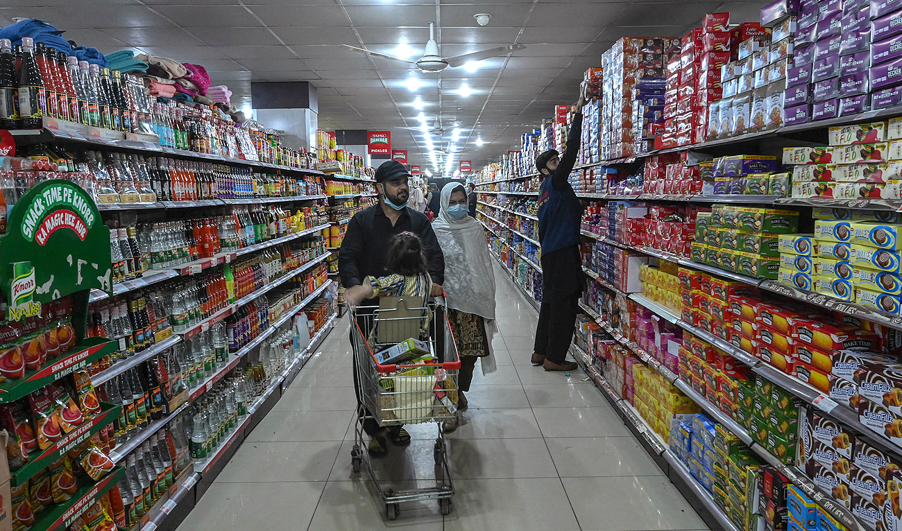 This photo, taken on March 20, 2023, shows people buying food items at a store in Peshawar. (Photo courtesy: AFP/File)