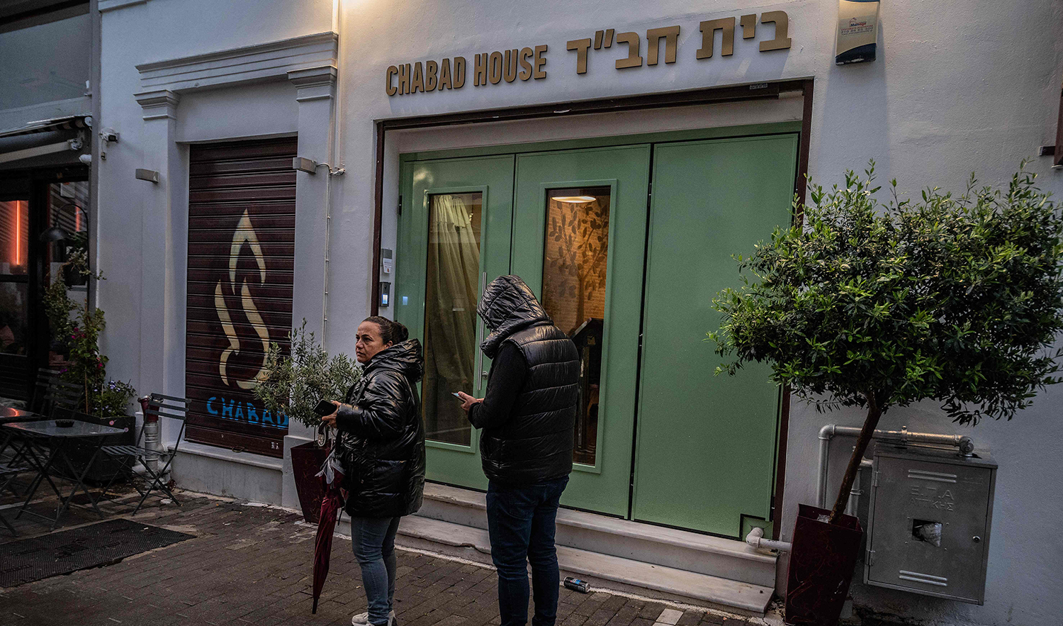 Members of the public stand in front of a Jewish restaurant in central Athens, Greece, on March 28, 2023. (AFP)