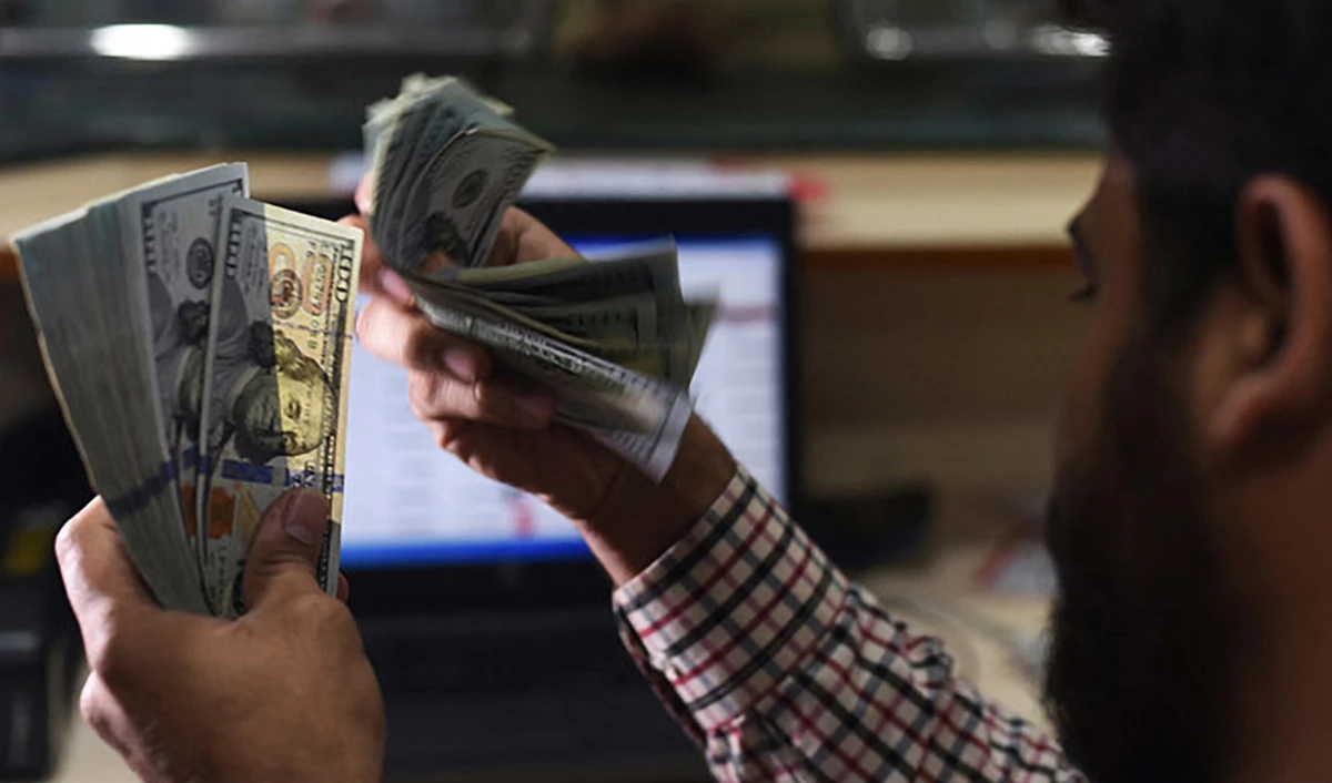 A Pakistani dealer counts US dollars at a currency exchange shop in Karachi, Pakistan, on October 9, 2018. (AFP/File)