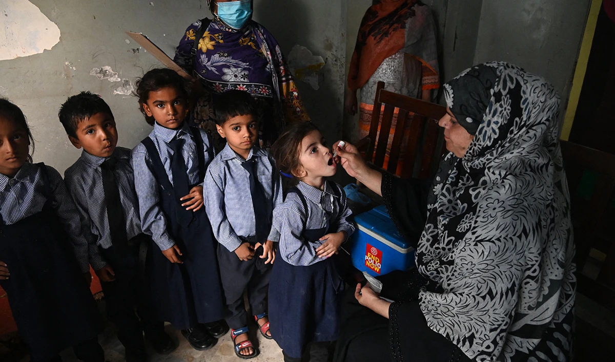 A health worker administers polio vaccine drops to a child during a vaccination campaign in Lahore on October 24, 2022. (AFP/FILE)