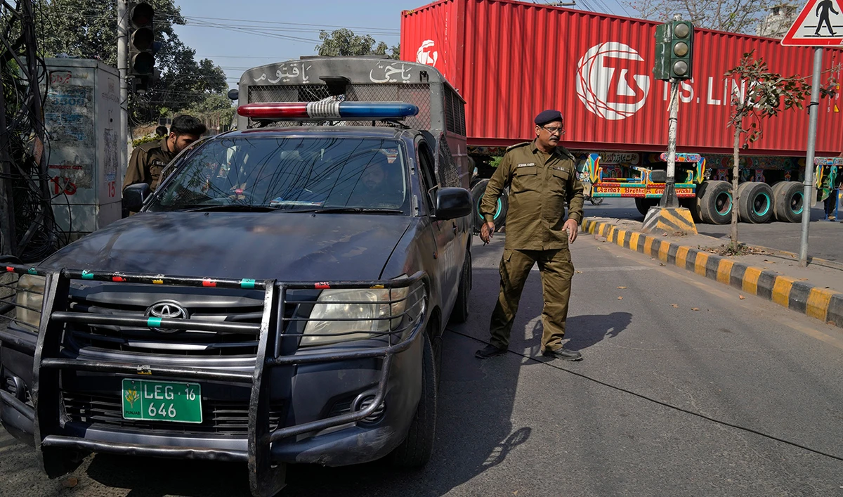 Police officers stand guard at a barricaded road leading to the residence of former Prime Minister Imran Khan, in Lahore, Pakistan, Thursday, March 16, 2023. (Photo courtesy: AP)