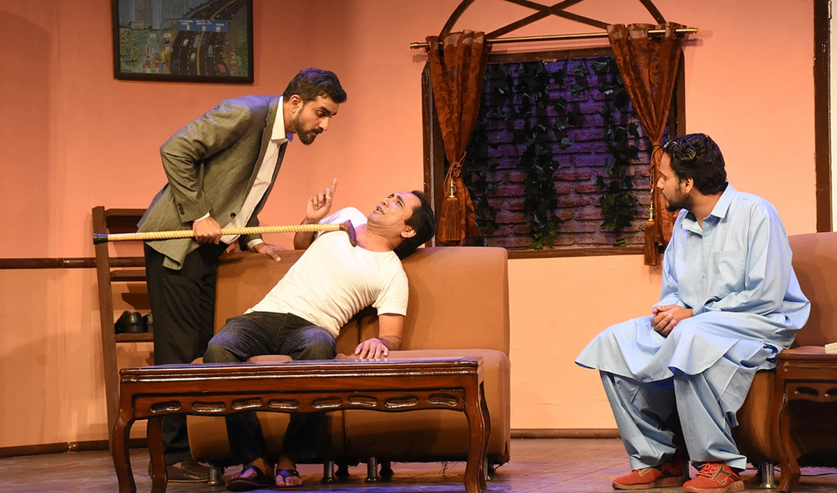 Actor Fawad Khan as Amjad threatens Irshad (Nazar-ul-Hasan) in a scene from “100 Din Chor Kay”, directed by Zeeshan Haider, at the Arts Council of Pakistan in Karachi, Pakistan, on December 17, 2022. (Photo courtesy: ACP)