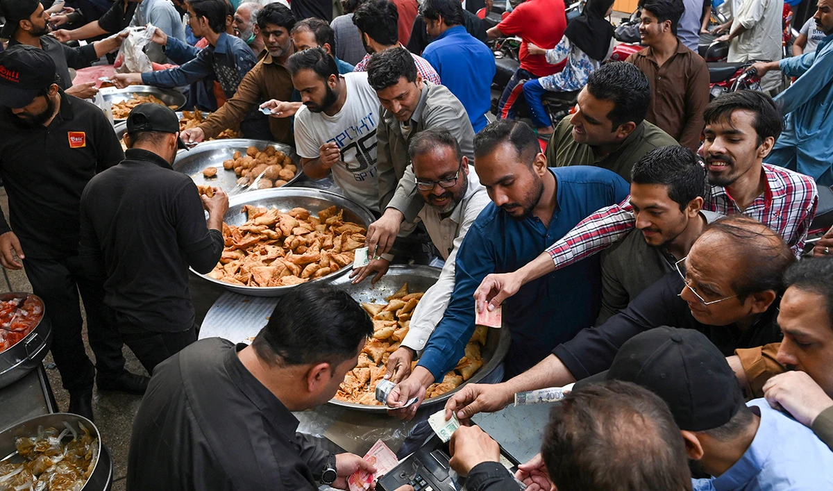 Muslim devotees buy Iftar food at a market before breaking their fast on the first day of the holy month of Ramadan, in Lahore on March 23, 2023. (AFP/FILE)