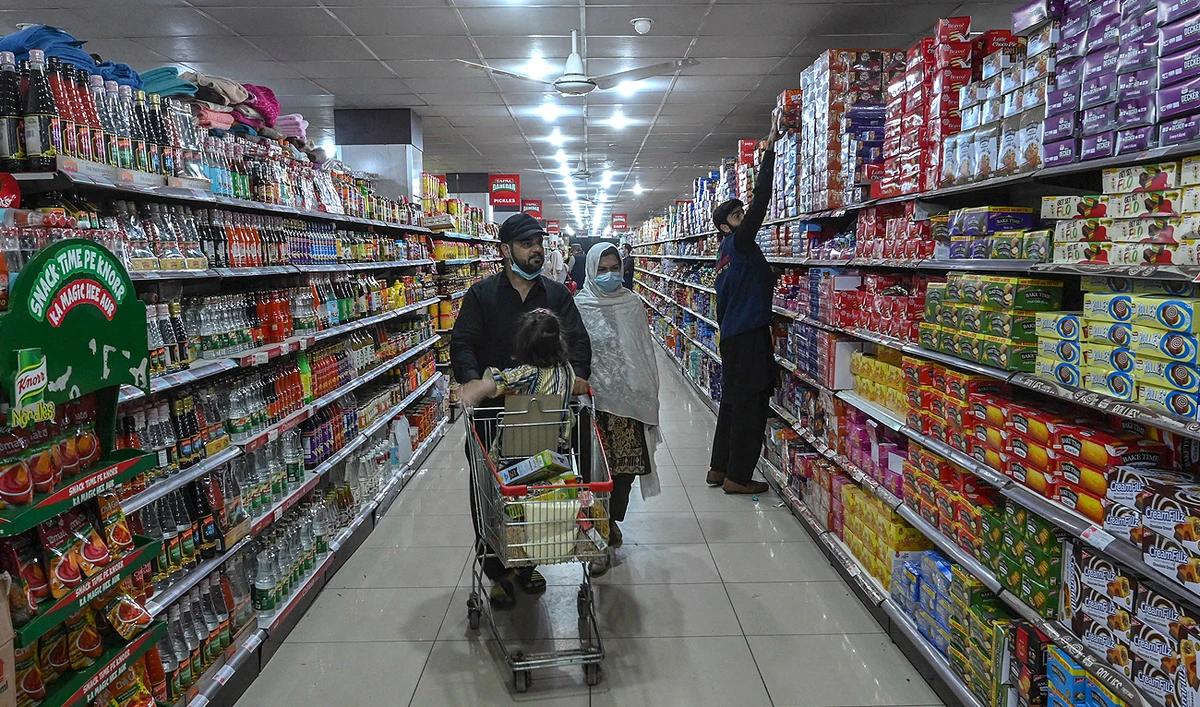 This photo, taken on March 20, 2023, shows people buying food items at a store in Peshawar. (Photo courtesy: AFP/File)