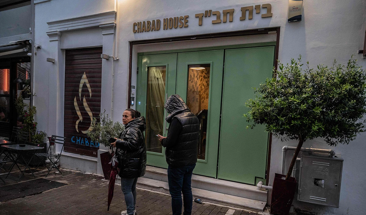 Members of the public stand in front of a Jewish restaurant in central Athens, Greece, on March 28, 2023. (AFP)
