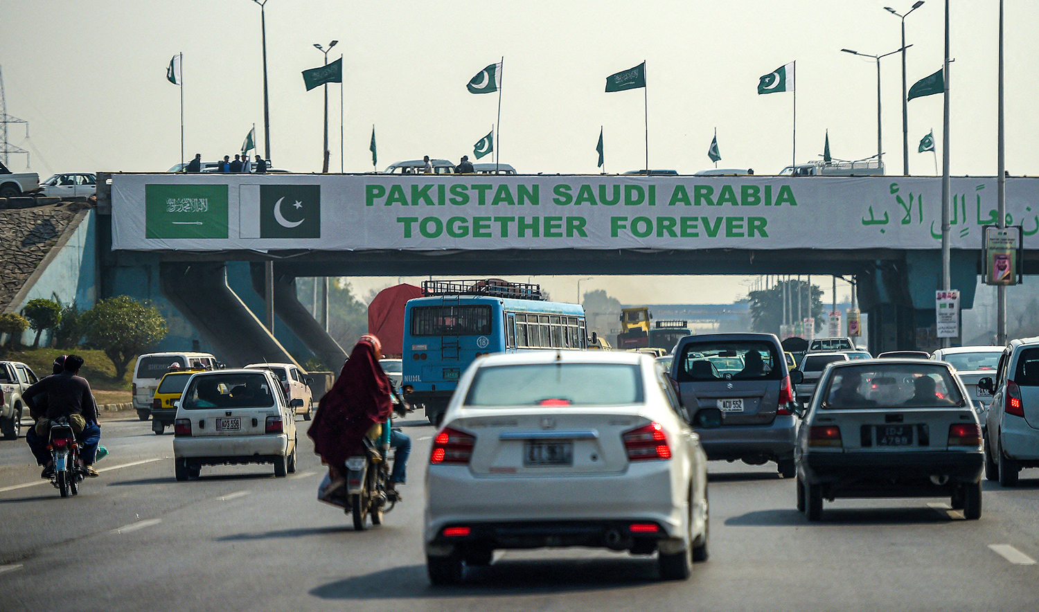 Pakistani commuters drive their vehicles under a banner welcoming Saudi Arabian Crown Prince Mohammed bin Salman displayed on a bridge, ahead of his arrival, in Islamabad on February 15, 2019. (AFP/File)