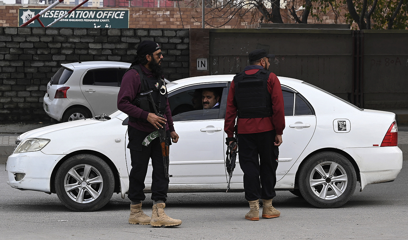 In this picture taken on February 1, 2023, policemen stand guard along a street in Peshawar.